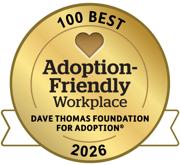 Gold medal badge reading “100 Best Adoption-Friendly Workplace, Dave Thomas Foundation for Adoption, 2026,” with a heart cutout at the top center and a white ribbon on either side.