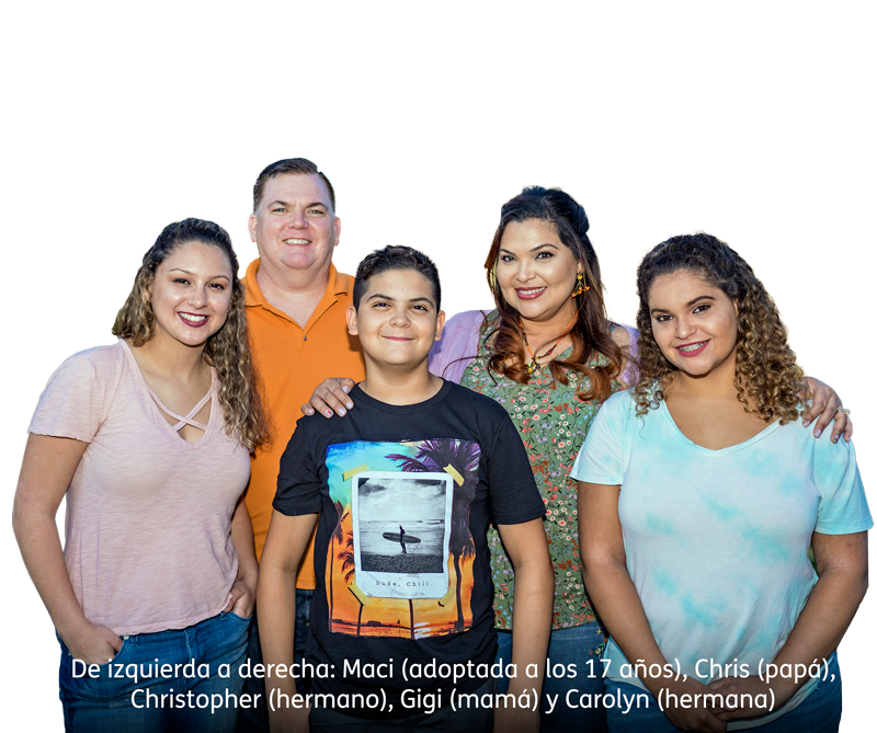A family of five stands close together and smiles at the camera against a white background. The text below identifies them and mentions that one daughter was adopted at age 17.