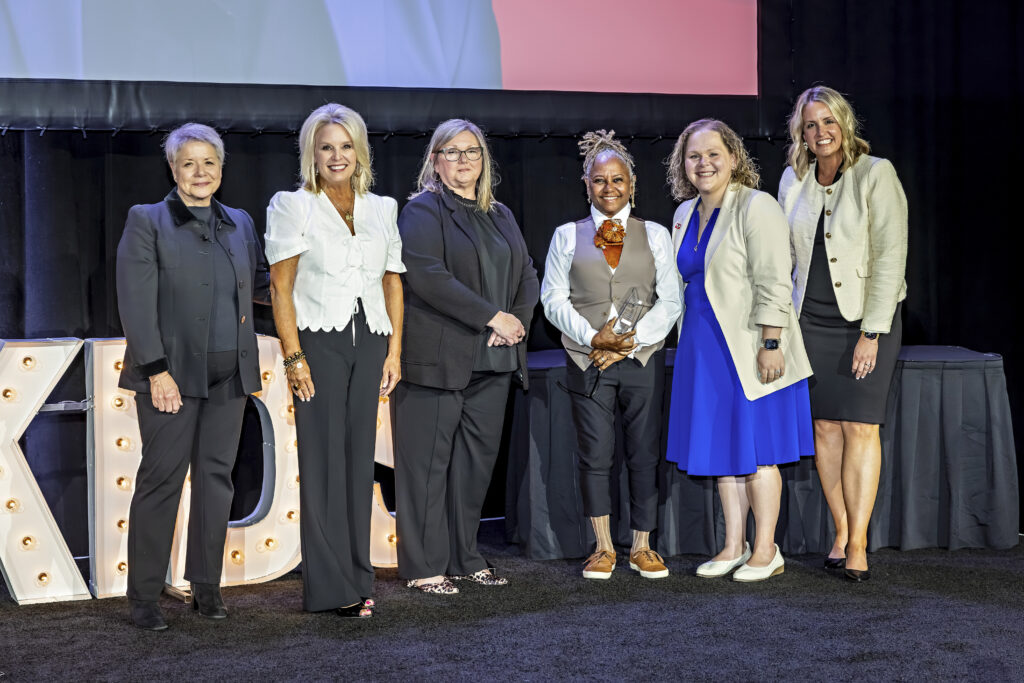 Robin accepting her award onstage, smiling alongside Foundation staff.