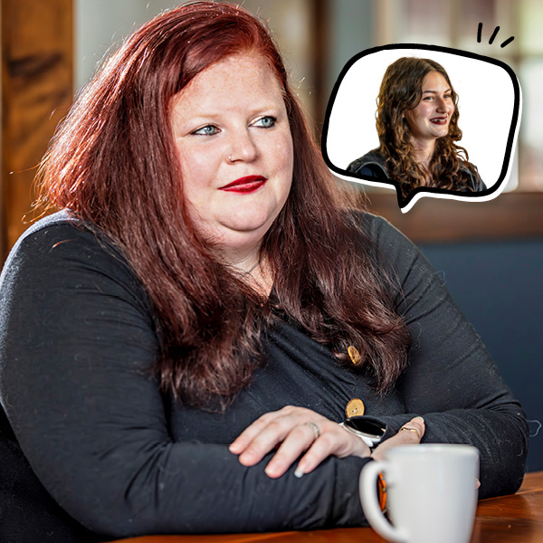 A woman with long red hair sits at a table with a white mug, looking thoughtful. A thought bubble shows another woman with wavy brown hair, smiling.