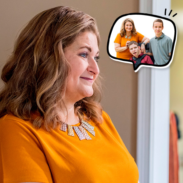 A woman with wavy hair and an orange shirt smiles while looking ahead. A thought bubble shows her with her two sons.