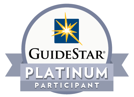 GuideStar Platinum Participant badge featuring a blue square with a yellow starburst, the words GuideStar in black, and a gray ribbon with Platinum Participant in bold white letters.