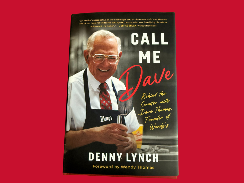 Book cover of Call Me Dave by Denny Lynch, featuring a smiling older man in glasses and a Wendys apron. The subtitle reads, Behind the Counter with Dave Thomas, Founder of Wendys.